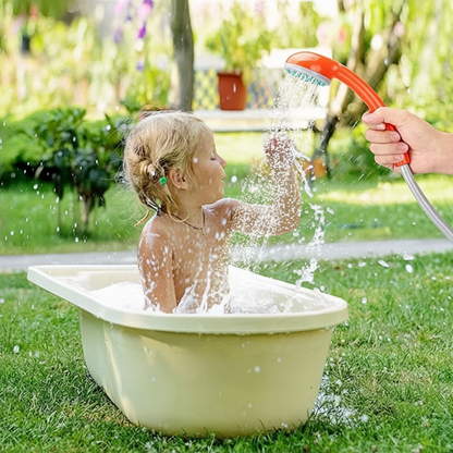 Child being bathed outdoors with portable shower
